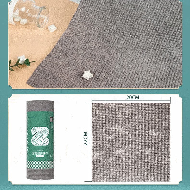 1 Roll/25pcs Disposable Kitchen Cleaning Cloth Roll  displays it's size and placed opened on a surface beside to a bottle and leaves 