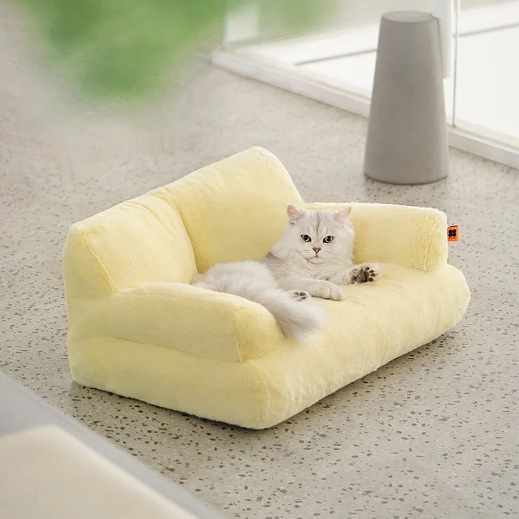 A cat lying on a yellow color Cat Sofa Couch Cushion