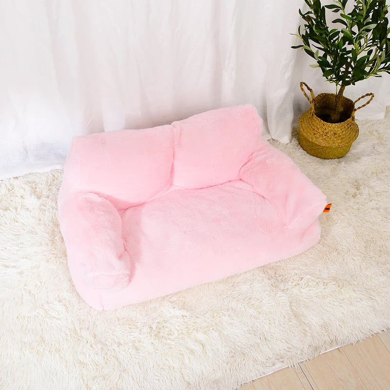 A pink color Cat Sofa Couch Cushion placed beside to a plant pot