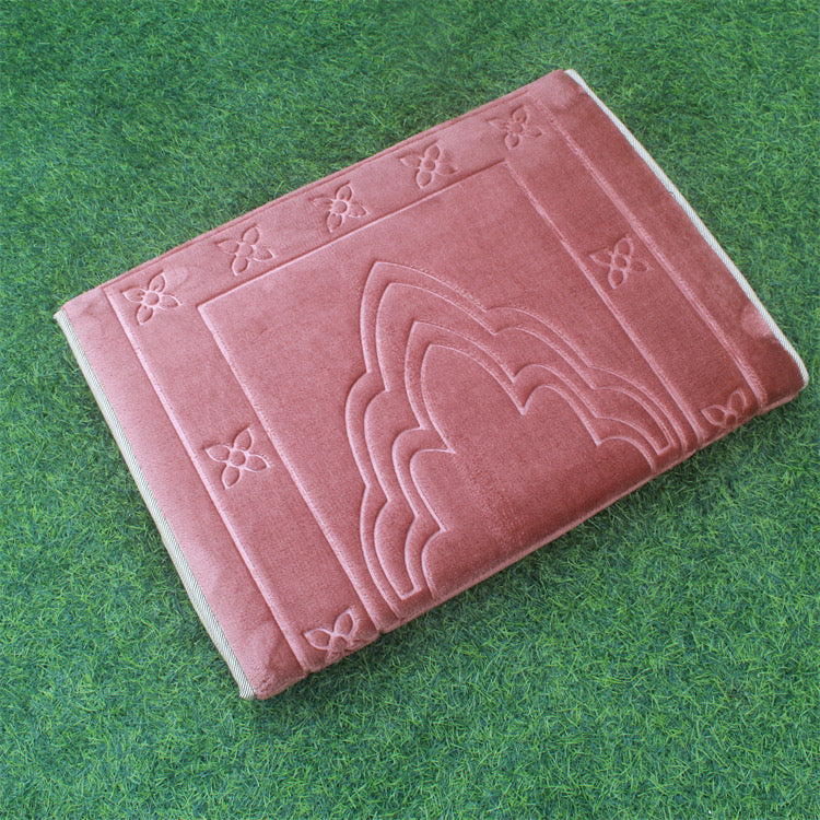 Folded Red color Islamic Foldable Prayer Mat kept on a grass