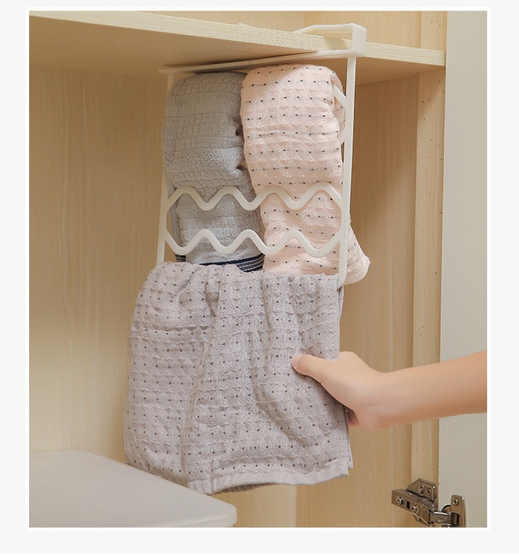 A person pulling a towel hung on  a Wardrobe Separation Board installed inside a cupboard