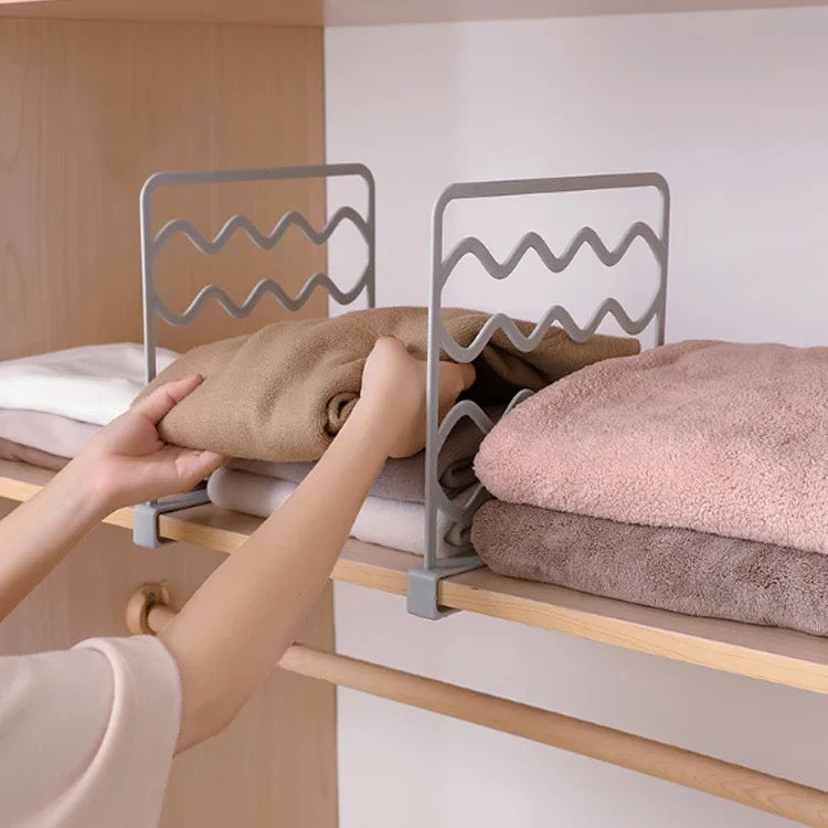 A person picking one towel from among towels separately organized using Wardrobe Separation Board 