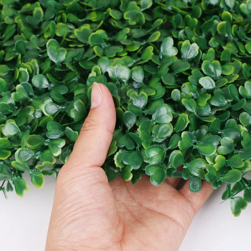 A person holding a portion of Artificial Grass Plant 