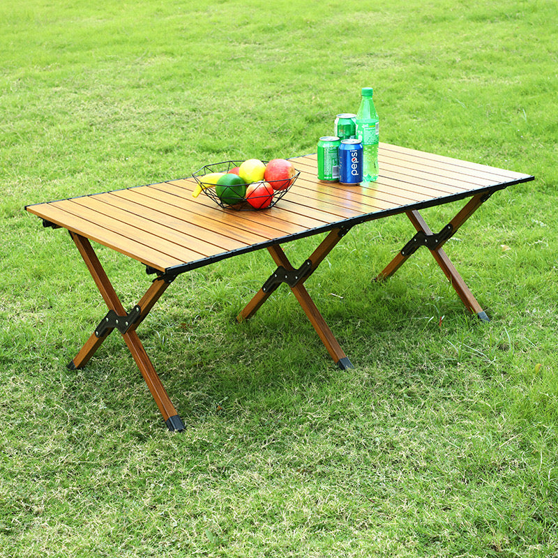 Outdoor Portable Camping Table with fruits and soft drinks kept on top of it situated in a park for picnic 