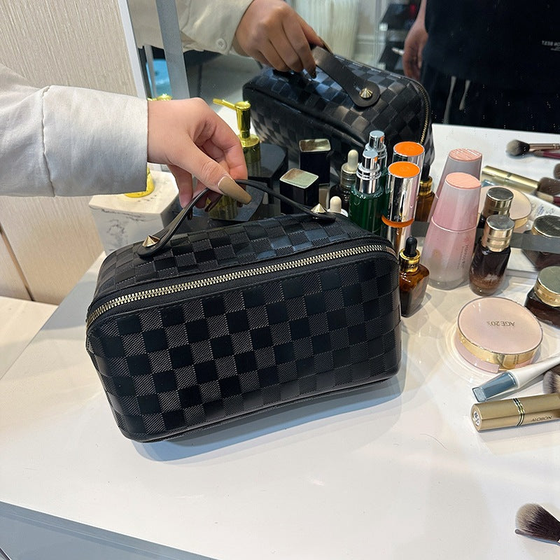 A person tending to place a Black color Cosmetic Bag on a makeup table with few cosmetic products in it