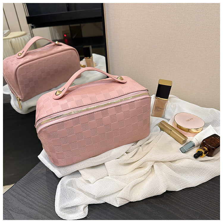 Pink color Cosmetic Bag kept next to cosmetic items on a table 