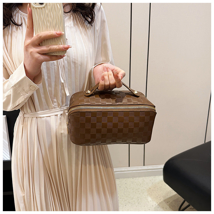 A lady taking a mirror selfie by carrying a Brown color Cosmetic Bag on her other hand