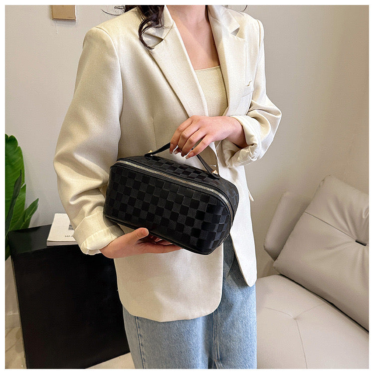 A woman carrying Black color Cosmetic Bag 