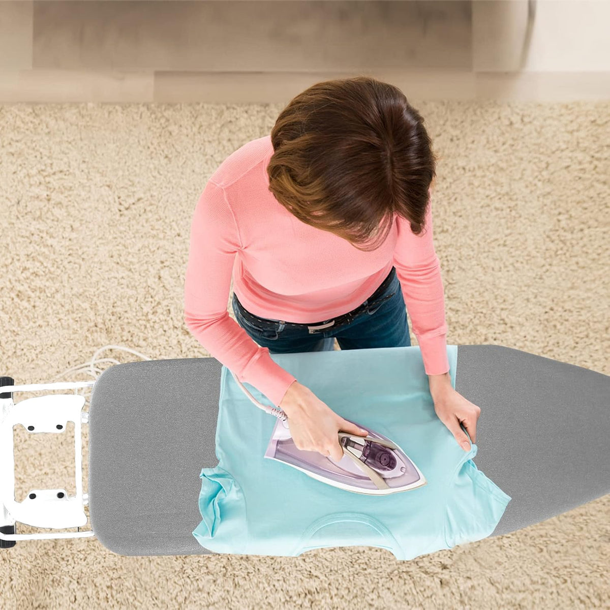 A Person is Ironing Her Clothes On Iron Board with Iron Holder.
