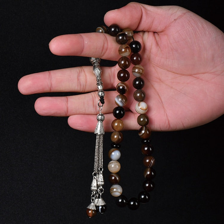 A Person is Holding an Islamic Tasbih Prayer Beads.