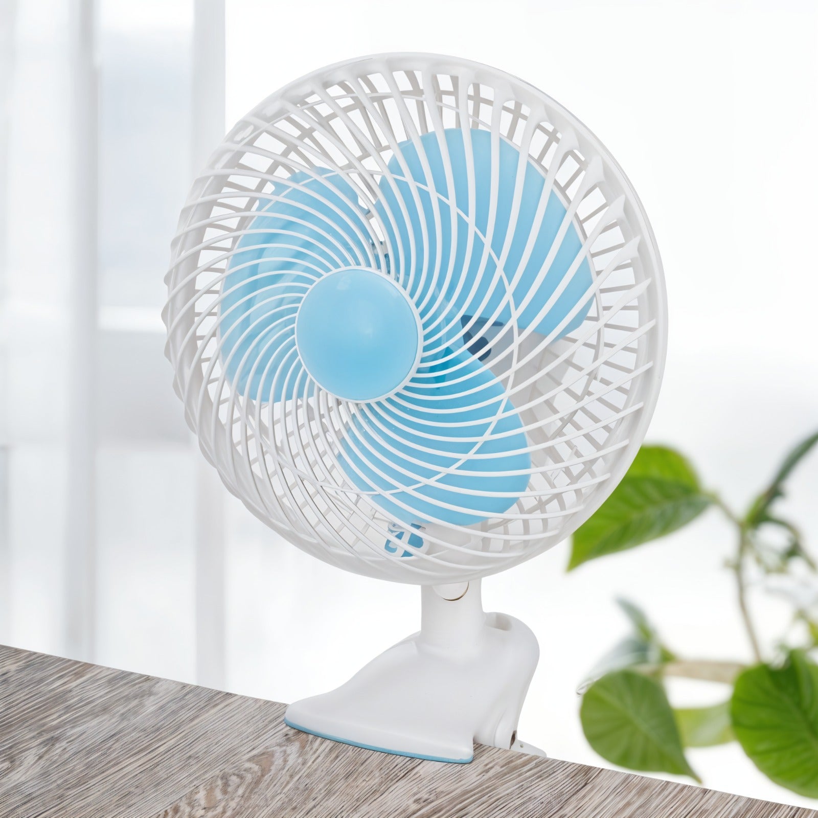 JIHAM 8-Inch Table & Clip Fan is Clipped on a Table.