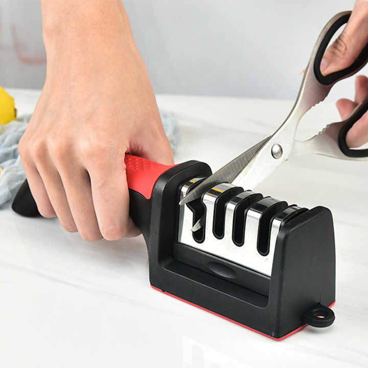 A Person is Sharpening Scissor Using Kitchen Knife Sharpener.