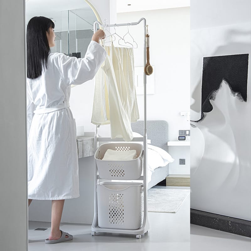 A Women is Hanging Clothes on a Laundry Storage Basket With Hanger.