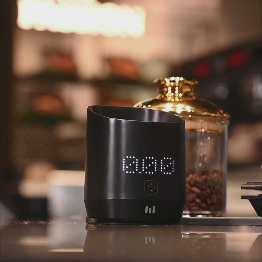 Macnoa MacScale Cup Digital Coffee Dosing Cup with LED display on a counter, blurred background