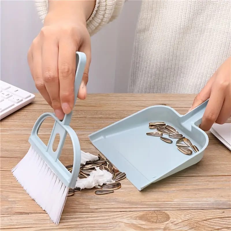 A Person is Cleaning Tabletop Using Blue Mini Dustpan Broom Set.