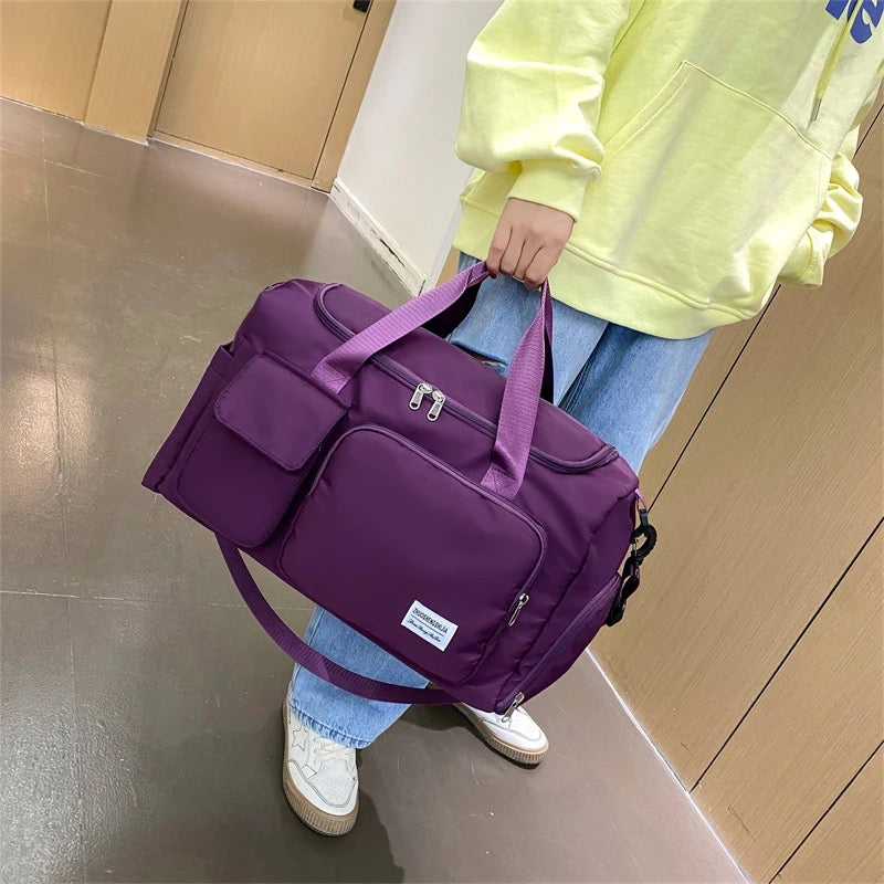 A Girl is Holding Multi-Pocket Travel Duffle Luggage Bag.