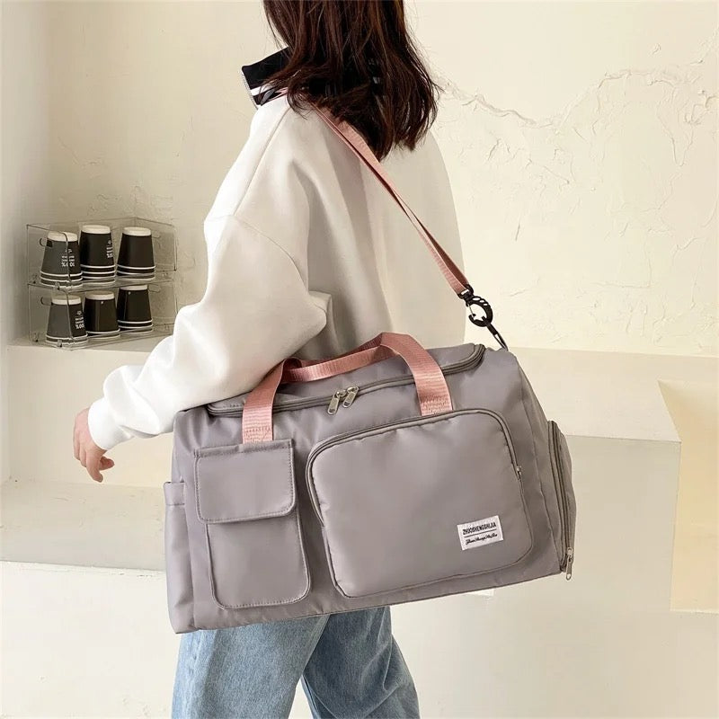 A Women is Carrying Multi-Pocket Travel Duffle Luggage Bag.