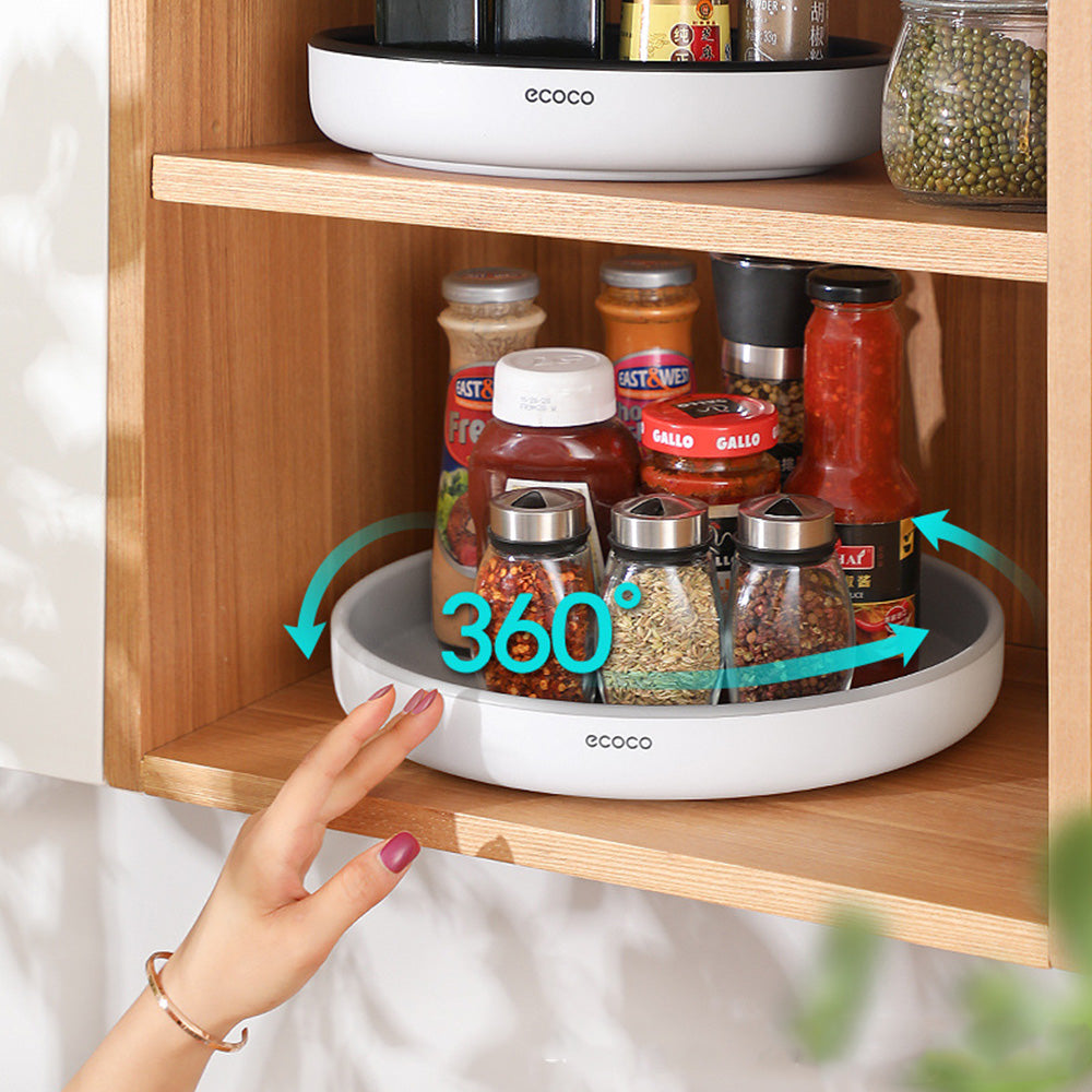 Someone is placing the Ecoco 360° Rotating Storage Tray with some items in it into a rack