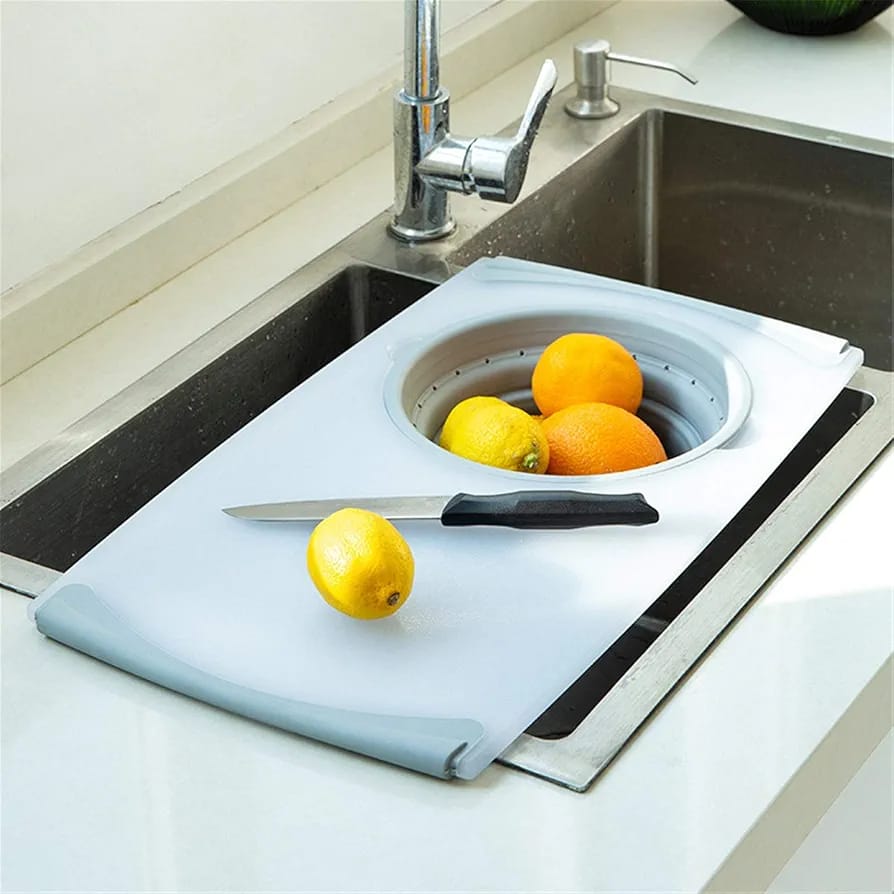 Multifunctional Chopping Board With Fruits and Knife Placed in a Kitchen Sink.