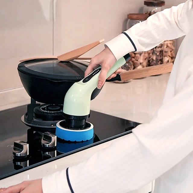 A person cleaning a stove with the help of the  9-in-1 Multifunctional Electric Cleaning Brush
