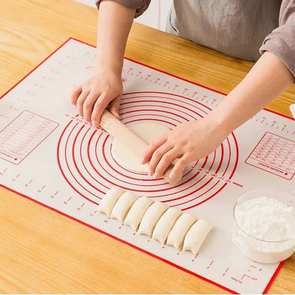 A Person is Spreading Dough in a Non-Slip Baking Mat With Measurements.