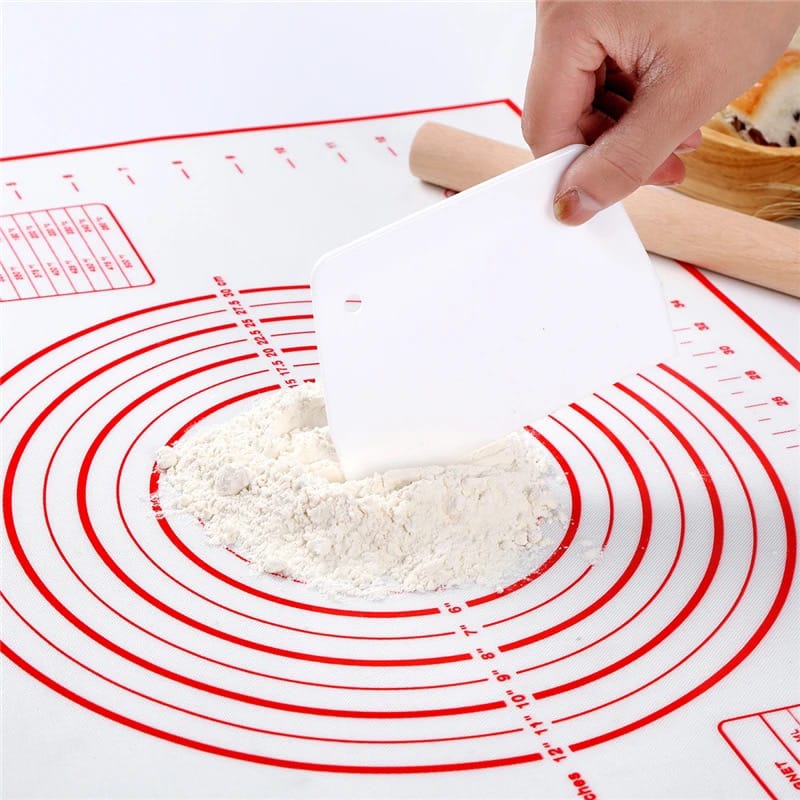 A Person Is Working On Flour in a Non-Slip Baking Mat With Measurements.