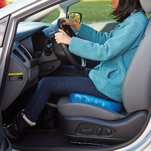 A lady driving a car with the assistance of an Egg Sitter Gel Chair Cushion