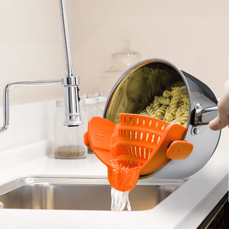 A Person is Straining Pasta By Attaching Adjustable Silicone Pot Pan Bowl Strainer.