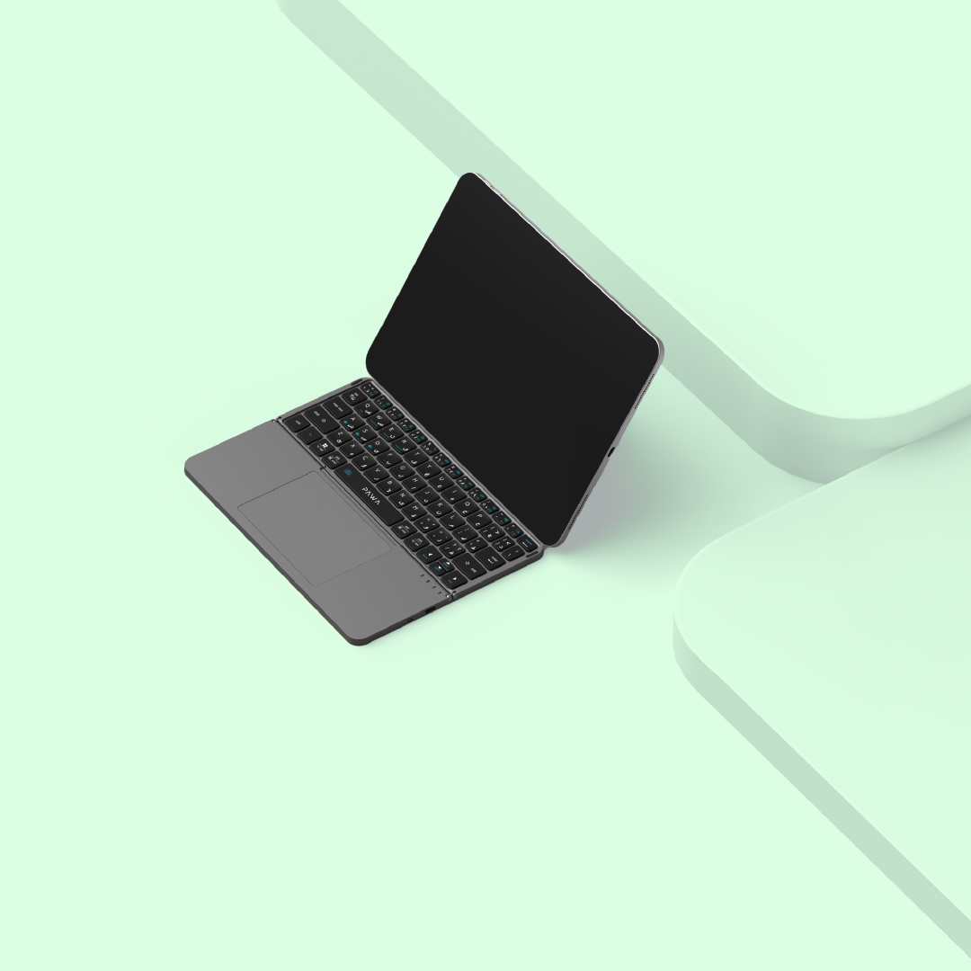 Black laptop with PAWA Foldable Wireless Bluetooth Keyboard on a light green surface