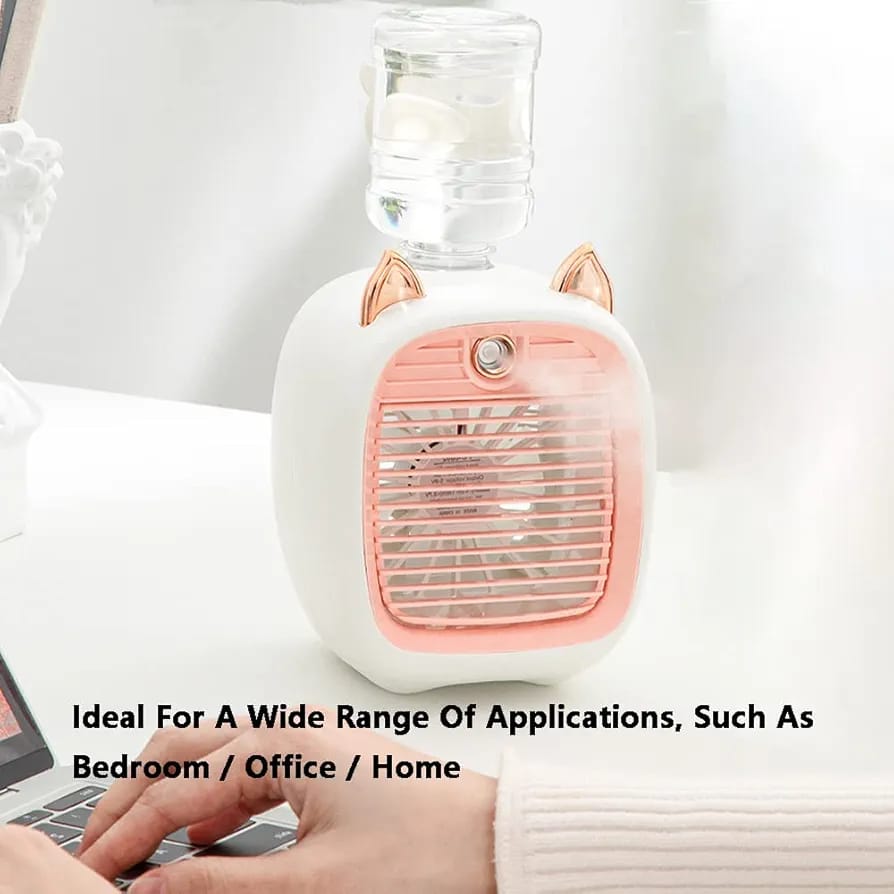 Mini Spray Cooling Fan in Pink Color is Placed Near a Person Who is Working in Laptop.