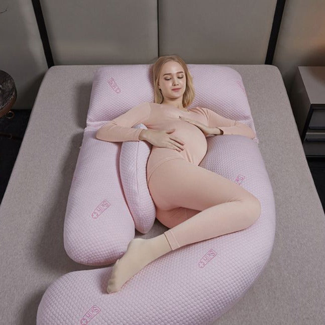 A Women is Lying On a Pregnancy Pillow.