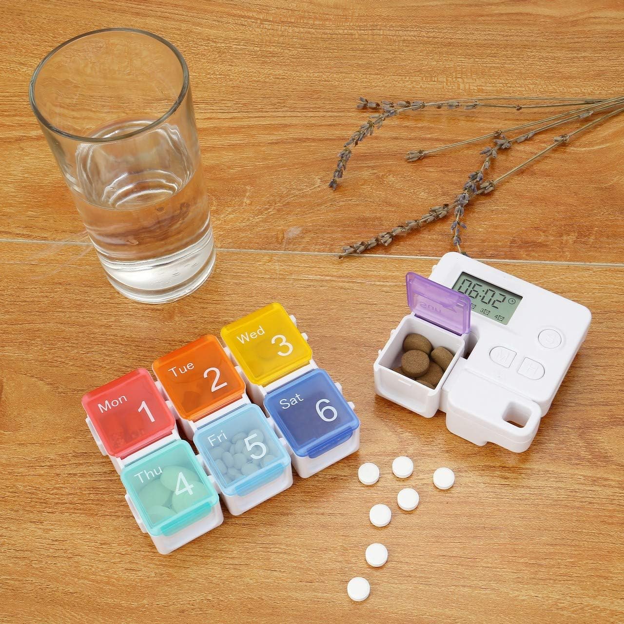 Portable Alarm Pill Box organized with pills along with a glass of water on a table.