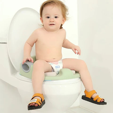 The baby is sitting on the Potty Training Toilet Seat with Soft Cushion Handles