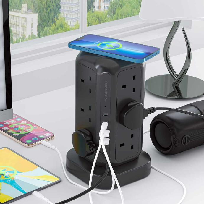 Powerology 12 Socket Multi-Port Tower Hub on the top, with a phone placed on the table next to a tablet, mobile, and speaker, all conveniently plugged into it