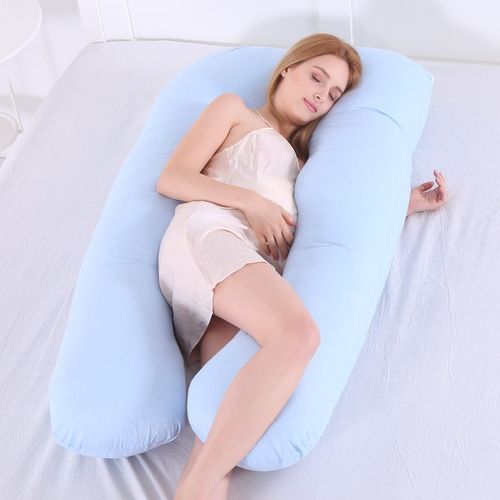 A pregnant woman sleeping on a supportive pregnancy pillow.