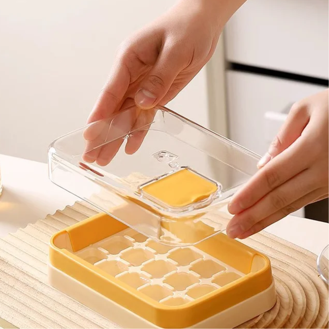 A Person is Holding the Lid Of Press Type Ice Cube Making Tray Mold.