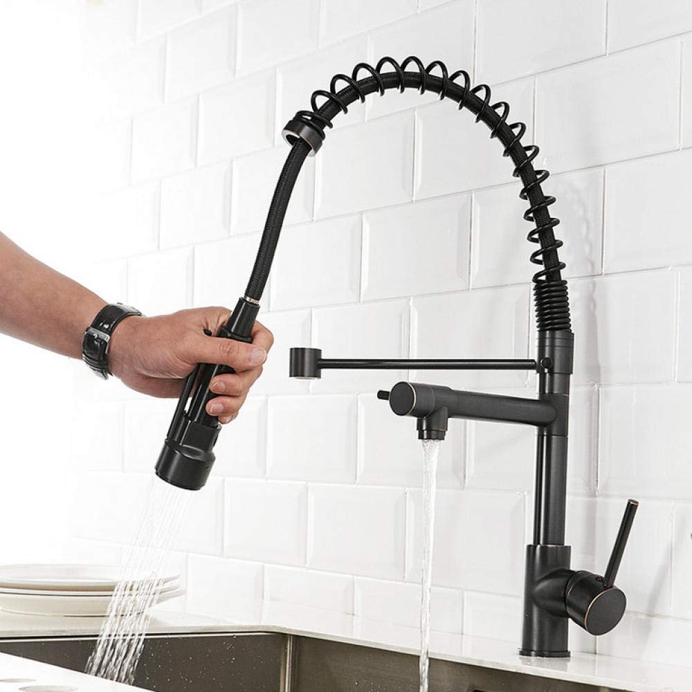 Pull Down Kitchen Faucet with a person turning on the water, set against a white tiled wall.