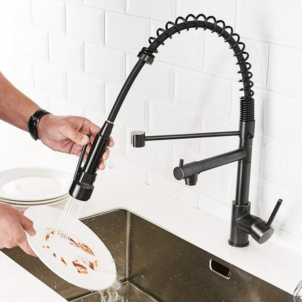 Person washing a plate under a Pull Down Kitchen Faucet in a kitchen setting.