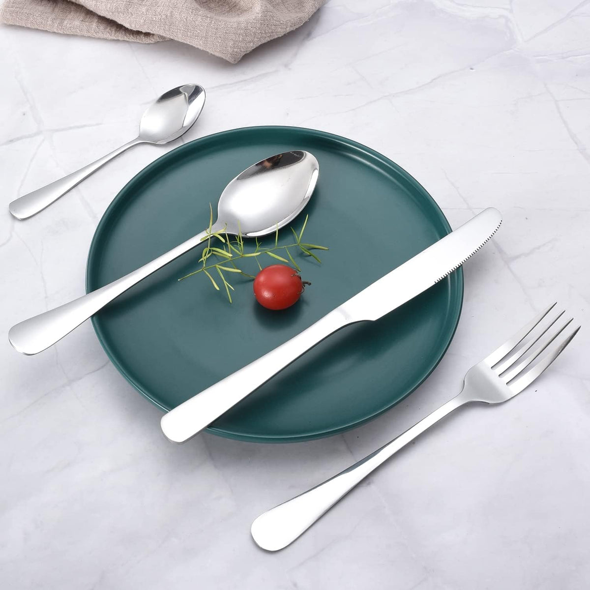 Elegant stainless steel 24-piece cutlery set arranged in a table.