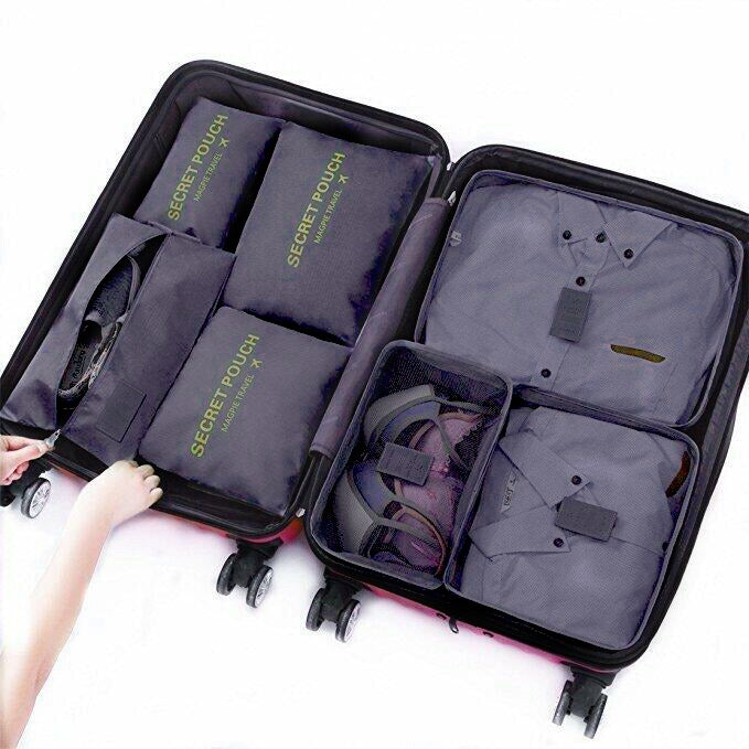 Open suitcase with 7 Pcs Travel Organizer Bags Packing Cubes Set labeled 'Secret Touch' on a white background