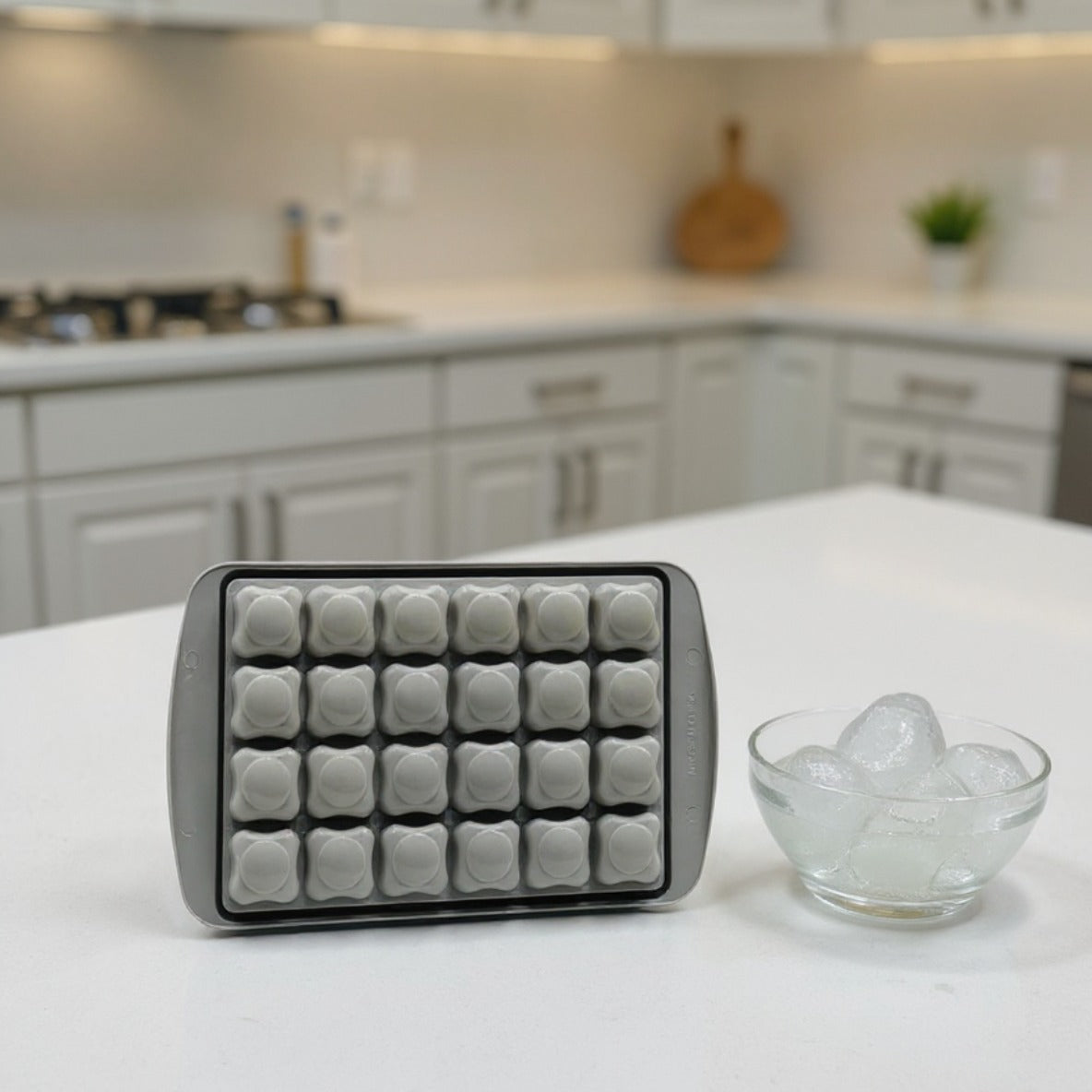An Ice Cube Tray is Placed on a Kitchen Cabinet Along with a Bowl of Ice Cubes.