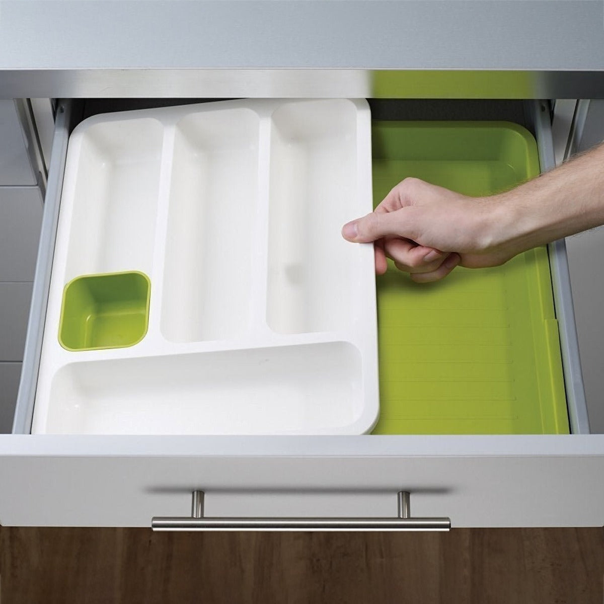 A Person is Fixing Expandable Cutlery Tray in a Drawer.