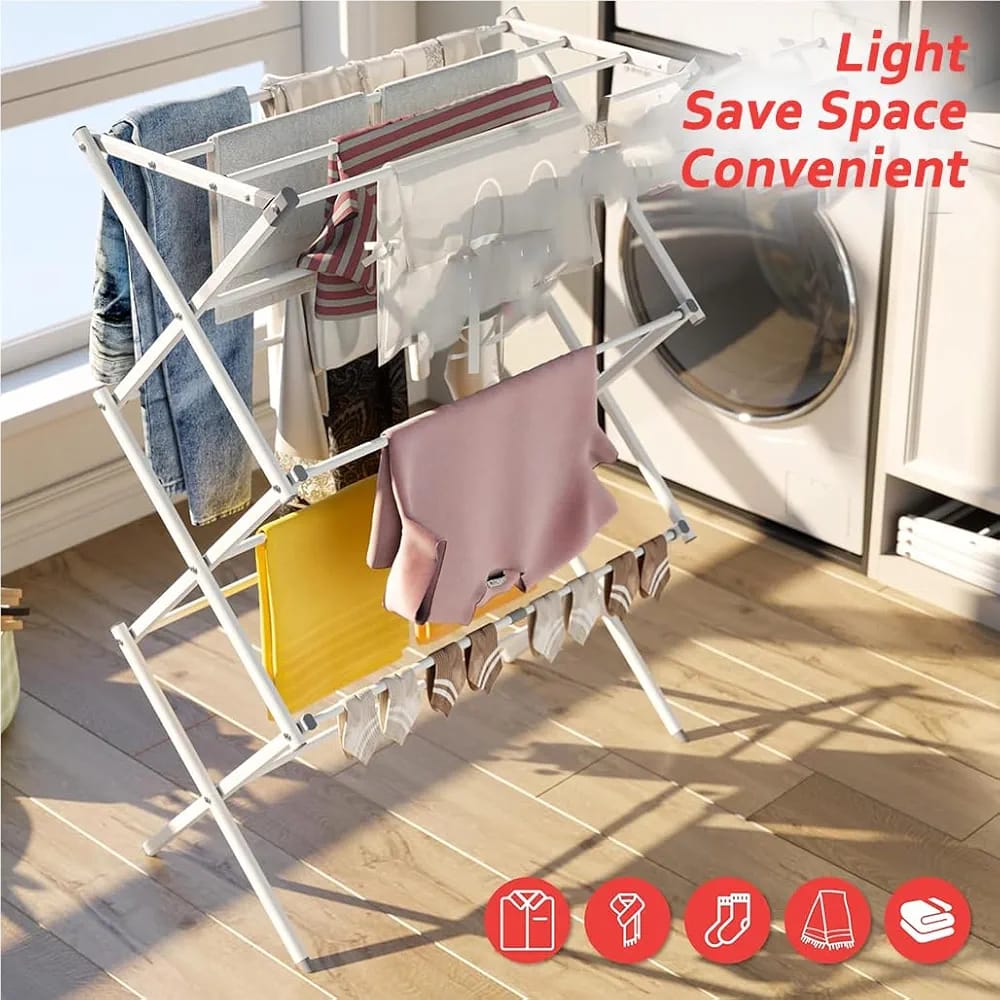 A 3-tier expandable clothes drying rack is placed on a wooden floor in the background, and a window provides natural light. Various garments, including shirts , pants, and socks, are hanging on its multiple rails and shelves. 