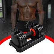 An adjustable dumbbell set is placed on its base. The setting appears to be a gym or workout area.