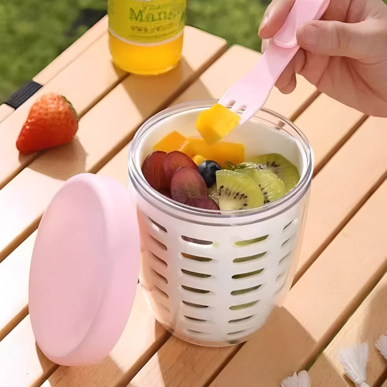 A Person is Eating From Drainable Fruit Storage Cup.