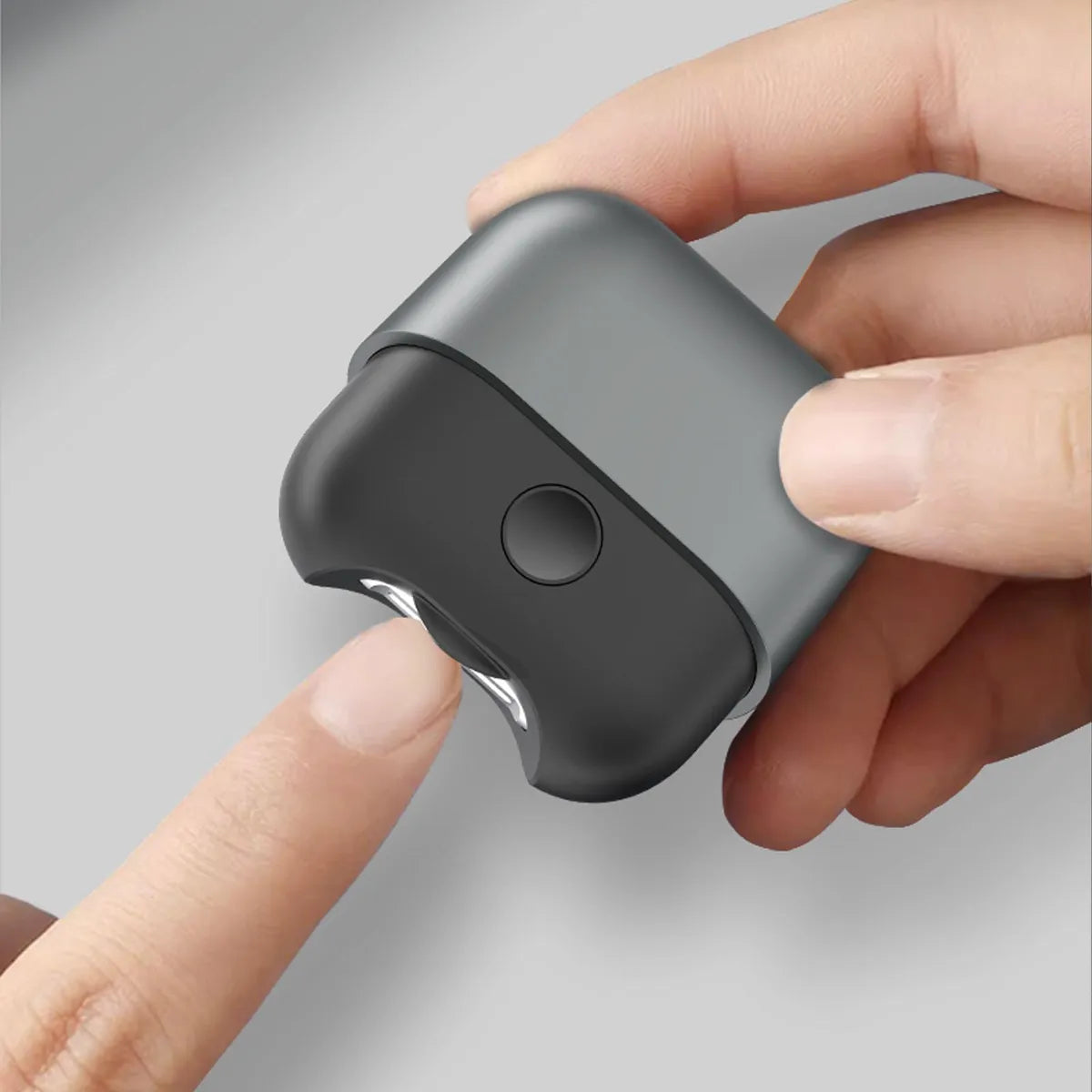 A person using an Electric Polishing Nail Clipper, holding the compact device and trimming their fingernail with precision.