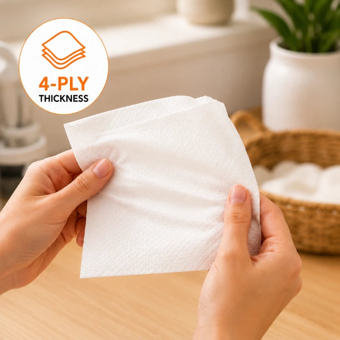 Person holding a 4-ply Extra Soft Tissue Pack towel with a blurred background of a kitchen.