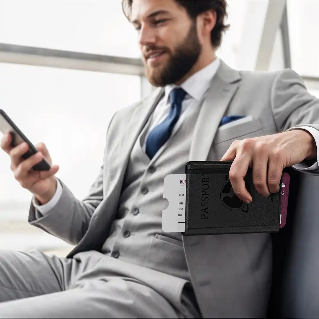 Man in a gray suit holding a smartphone and a Green Lion Pass-Track Passport Holder 