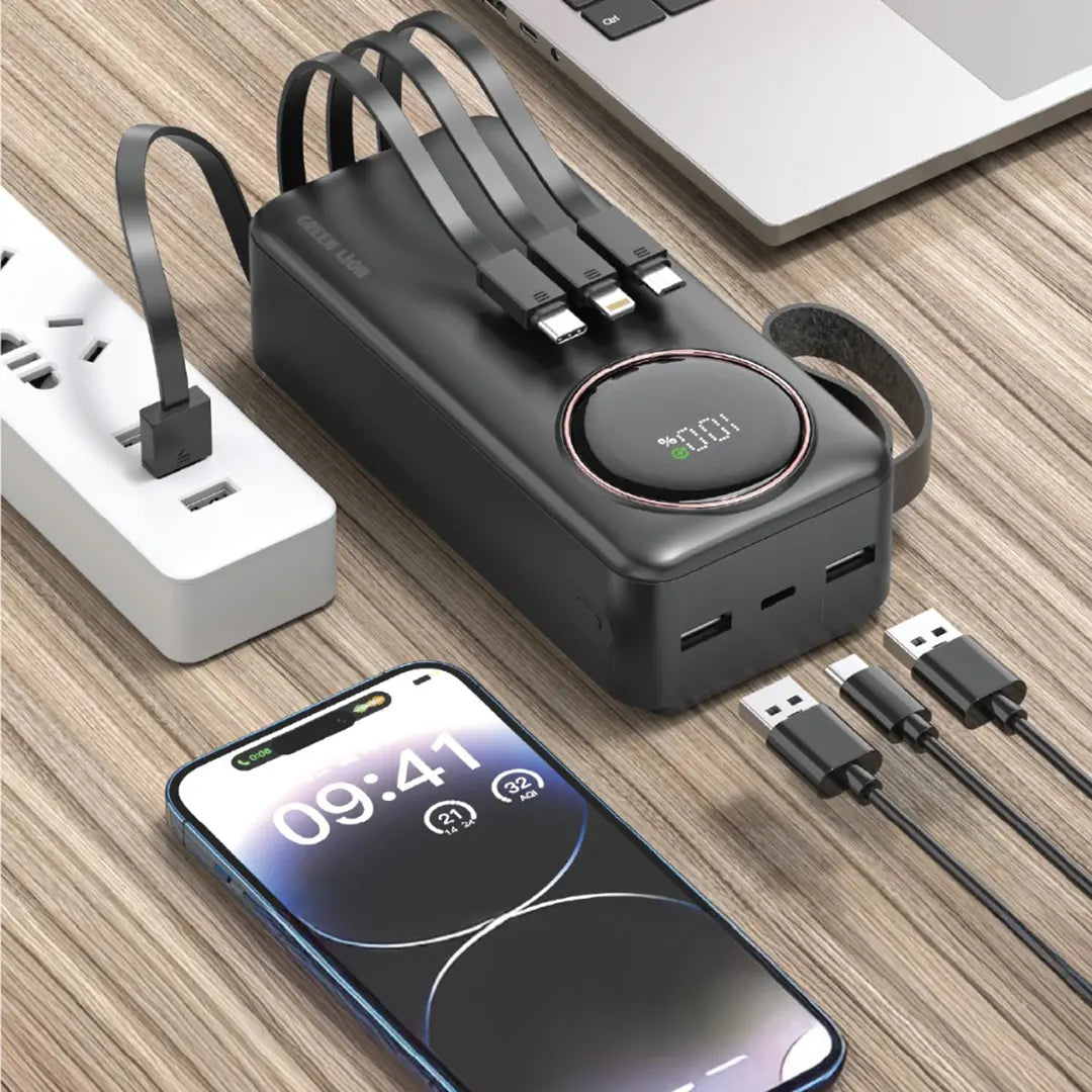 Black Green Lion Power Pulse Power Bank with multiple ports on a wooden surface next to a smartphone and laptop.