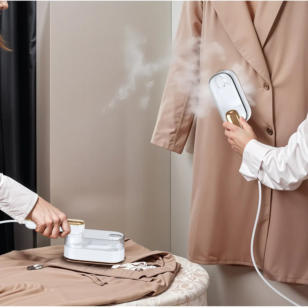 A person using the Green Lion Portable Mini Steam Iron to smooth out wrinkles on clothing, showing its powerful steam and dual-use design for both flat and hanging garments.